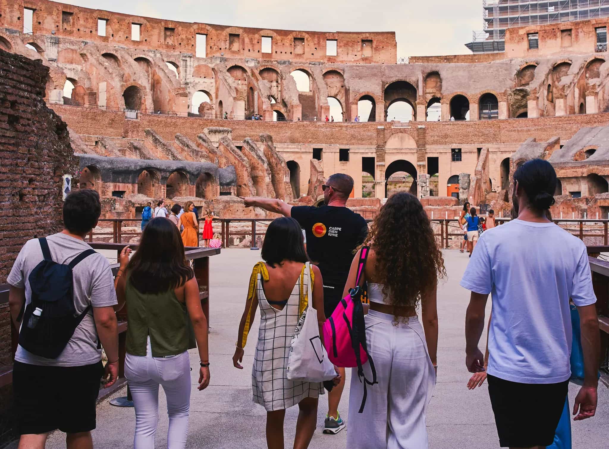 Tourists exploring ancient Colosseum arena floor and underground chambers during Carpe Diem Tours Rome historical experience