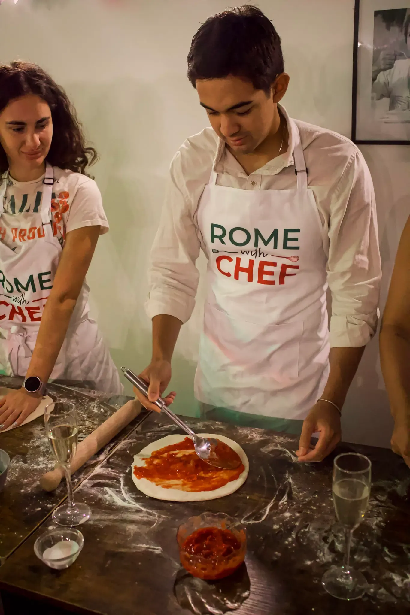 Adding sauce to pizza