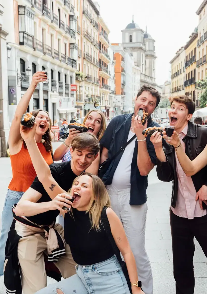 Happy group of tourists enjoying authentic Spanish tapas and drinks during Carpe Diem Tours Madrid food tour culinary experience and local gastronomy exploration