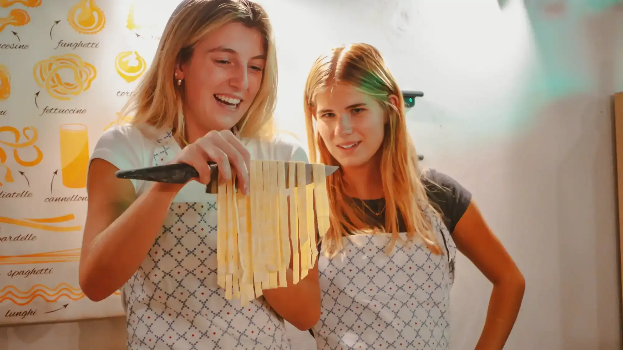 Tourists learning to make fresh pasta in hands-on cooking class during Carpe Diem Tours Rome culinary experience