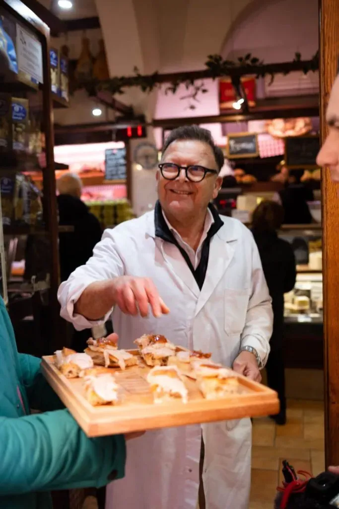 Vendor presenting a tray of Italian food samples during a Carpe Diem food tour in Rome