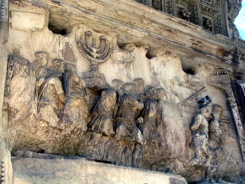 Ancient Roman relief carving from Arch of Titus depicting historical treasures and artifacts showcasing Roman Forum archaeological heritage during Carpe Diem Tours Rome historical exploration and cultural education experience