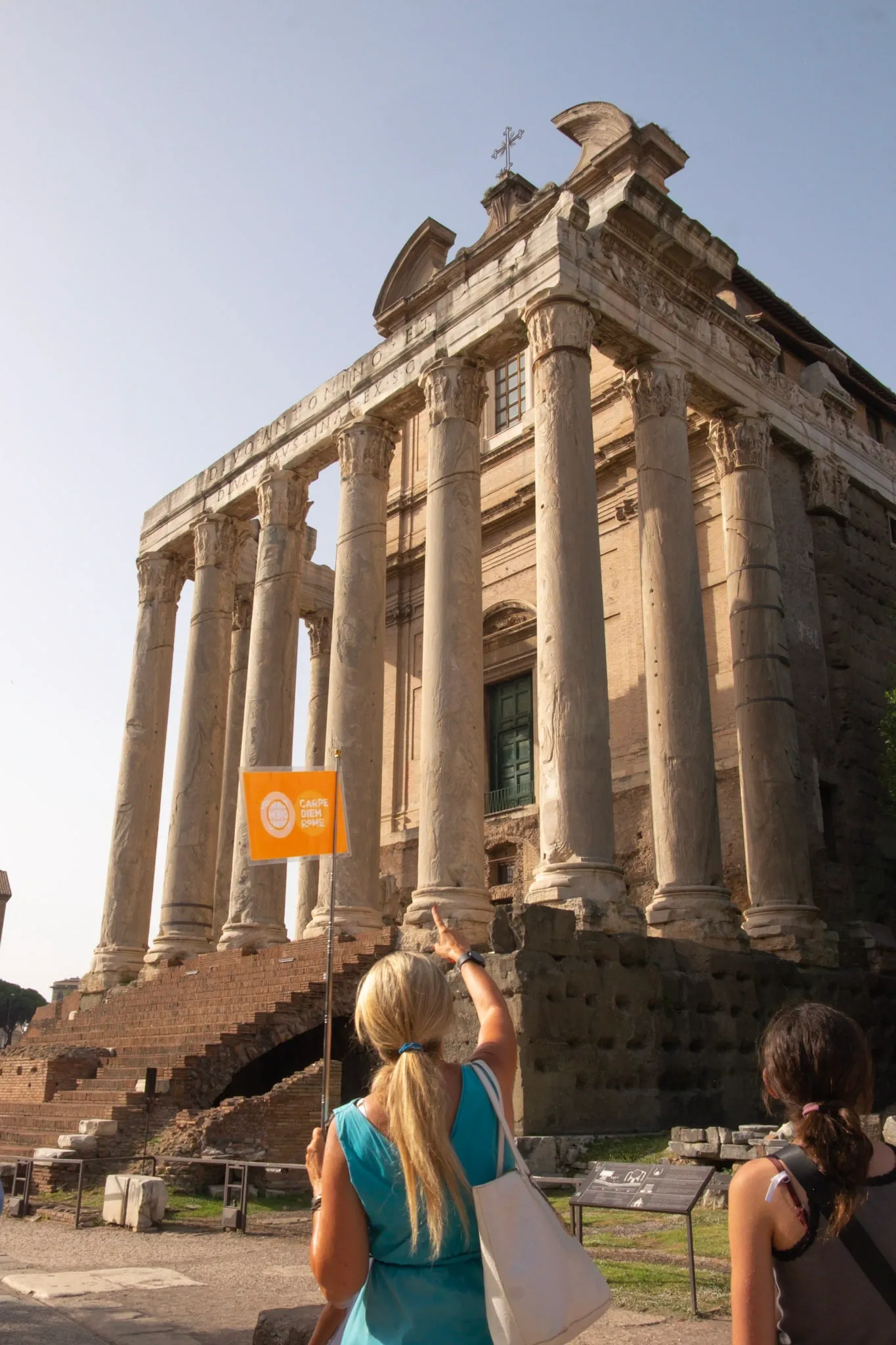 Guide is holding yellow flag on the Roman Forum