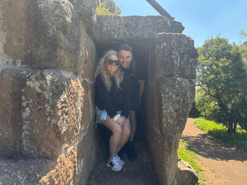 Couple inside the conduit of an ancient aqueduct in the Aqueduct Park near the Appian Way