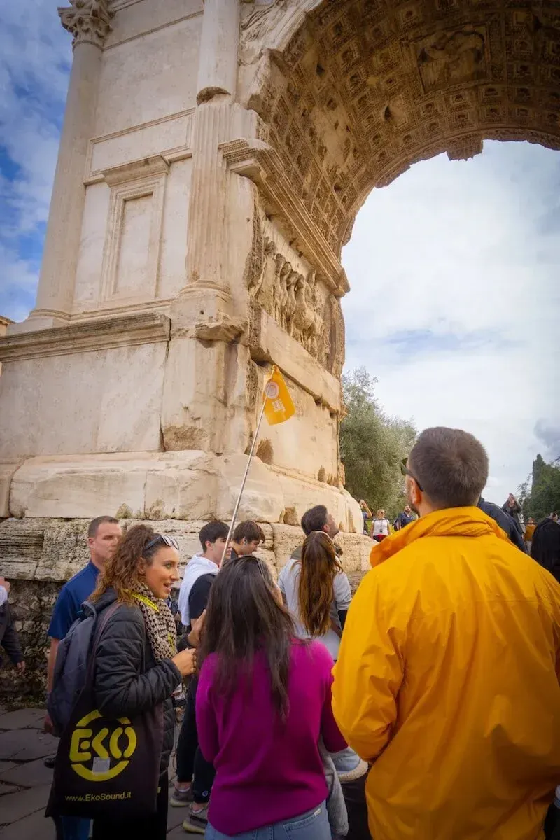 Guide beneath the Arch of Titus in the Roman Forum on our Colosseum tour