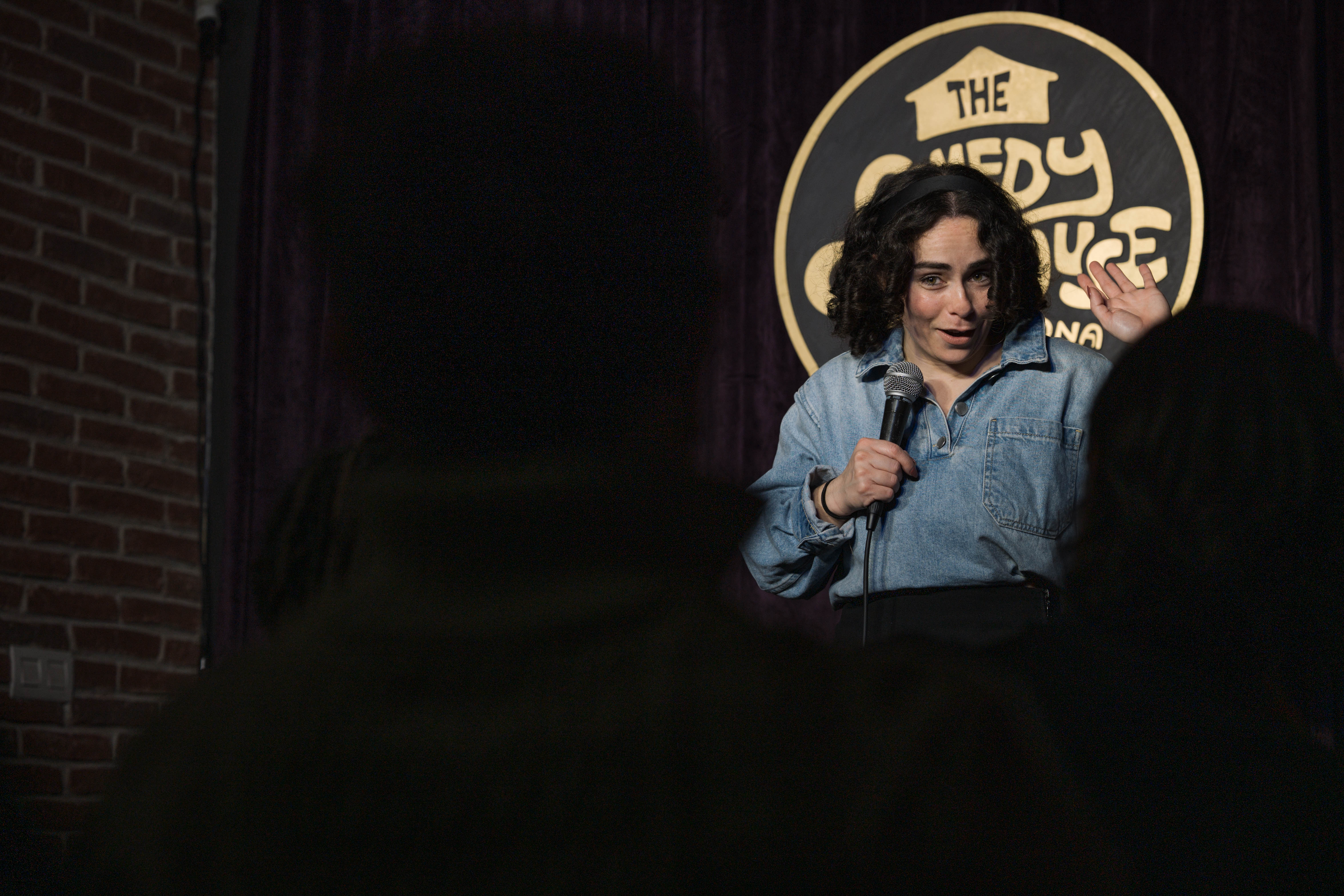 woman standing on stage at a stand up comedy event in Barcelona