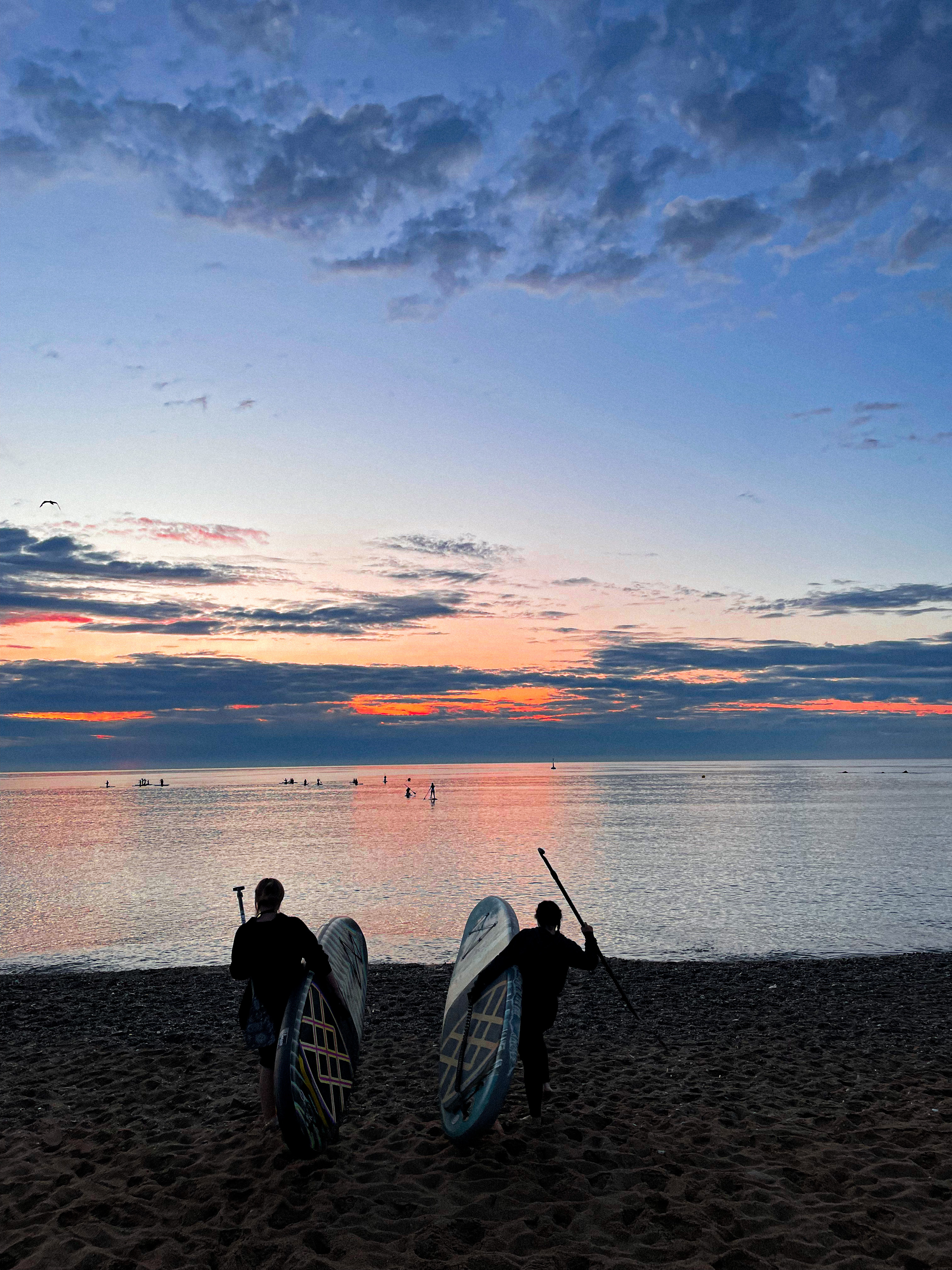 Couple paddleboarding at Barceloneta Beach in Barcelona