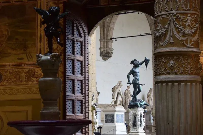 View of the Loggia dei Lanzi statues from the Palazzo Vecchio courtyard in Florence
