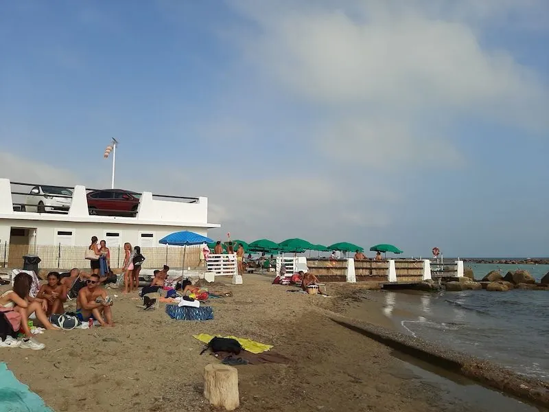 View of Spiaggia Libera beach in Santa Marinella, Italy with beachgoers and umbrellas
