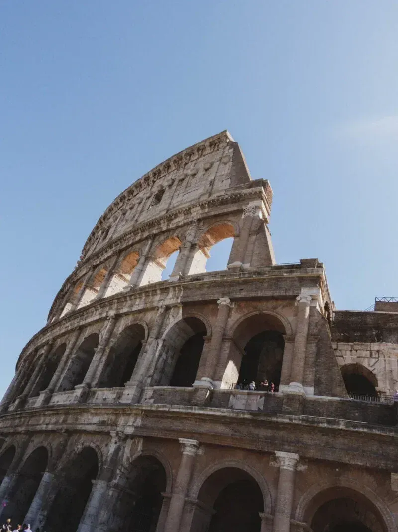 Group exploring the Colosseum arena with views of Palatine Hill and Roman Forum