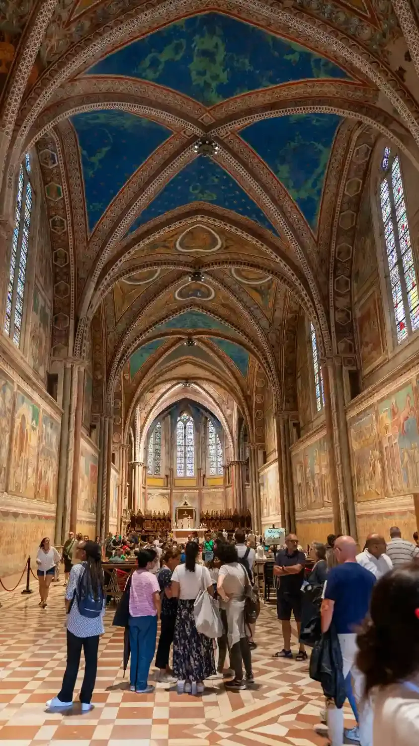 Interior of Basilica of Saint Francis with ornate vaulted ceiling frescoes stained glass windows