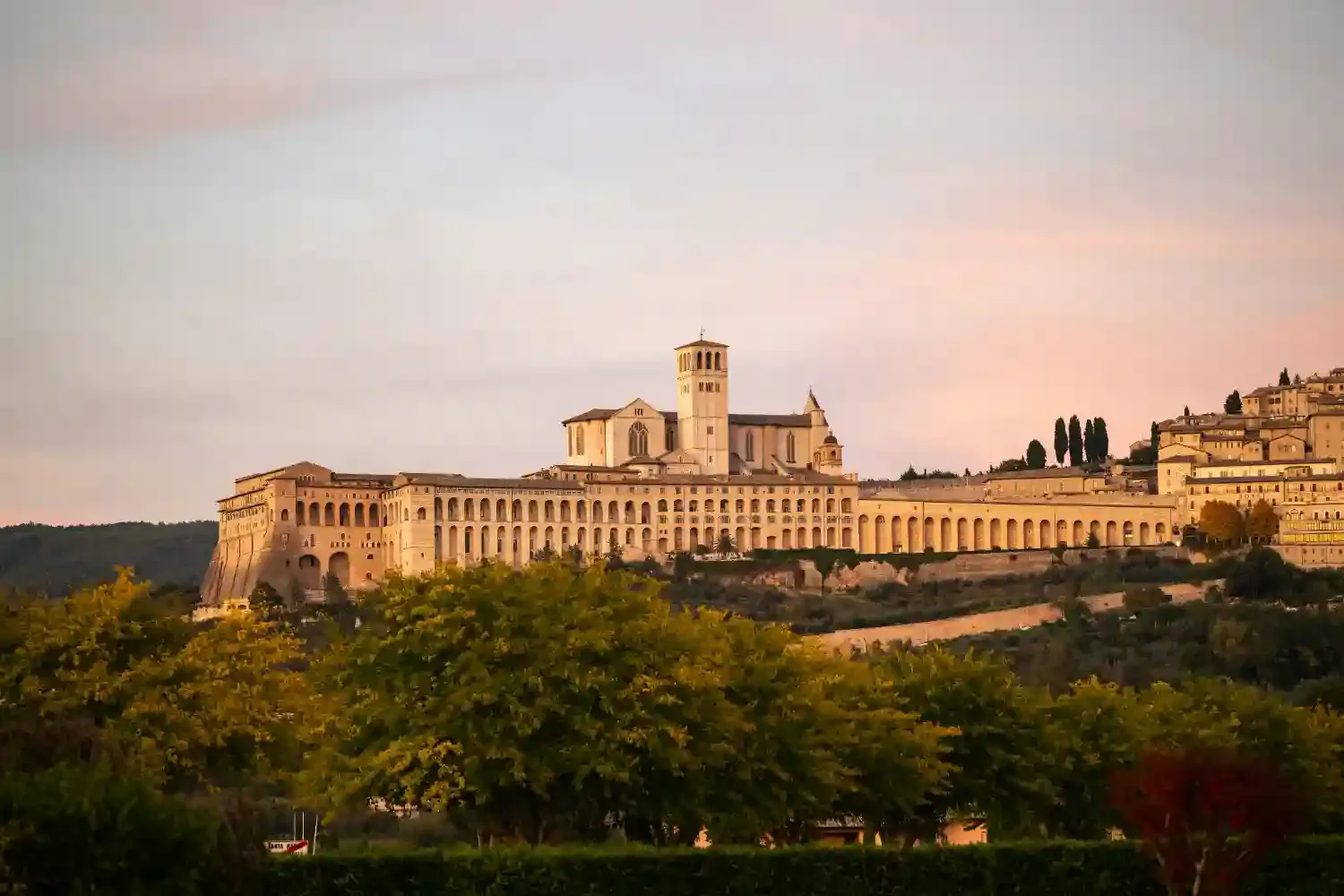 Basilica of Saint Francis in Assisi at sunset with golden light illuminating the historic religious complex