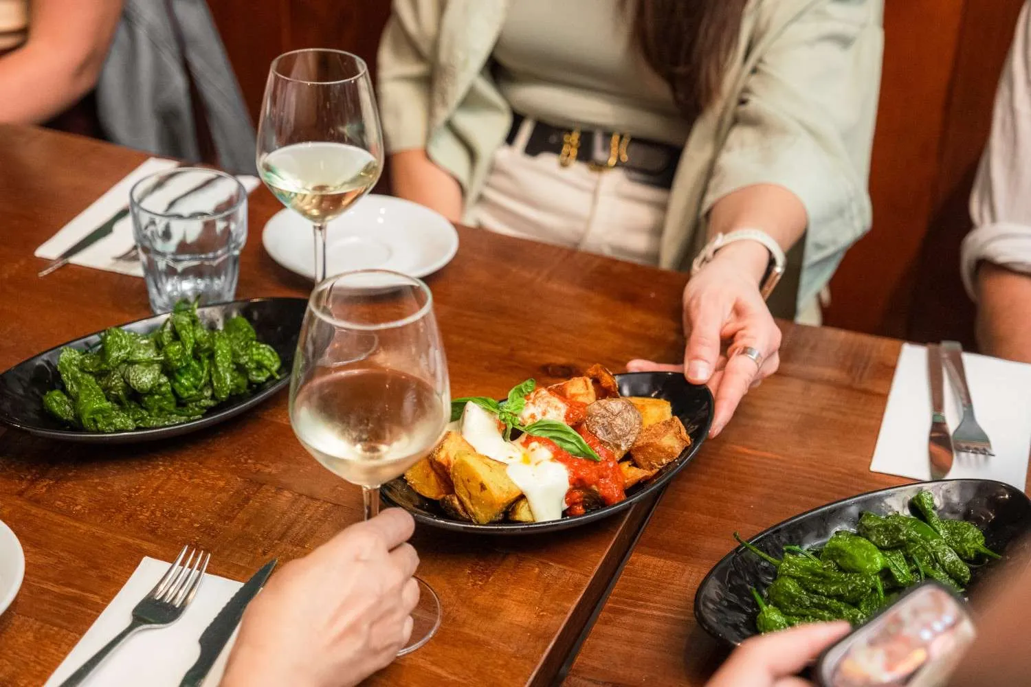 Patatas bravas and pimientos de Padrón paired with white wine on the Barcelona Food Tour