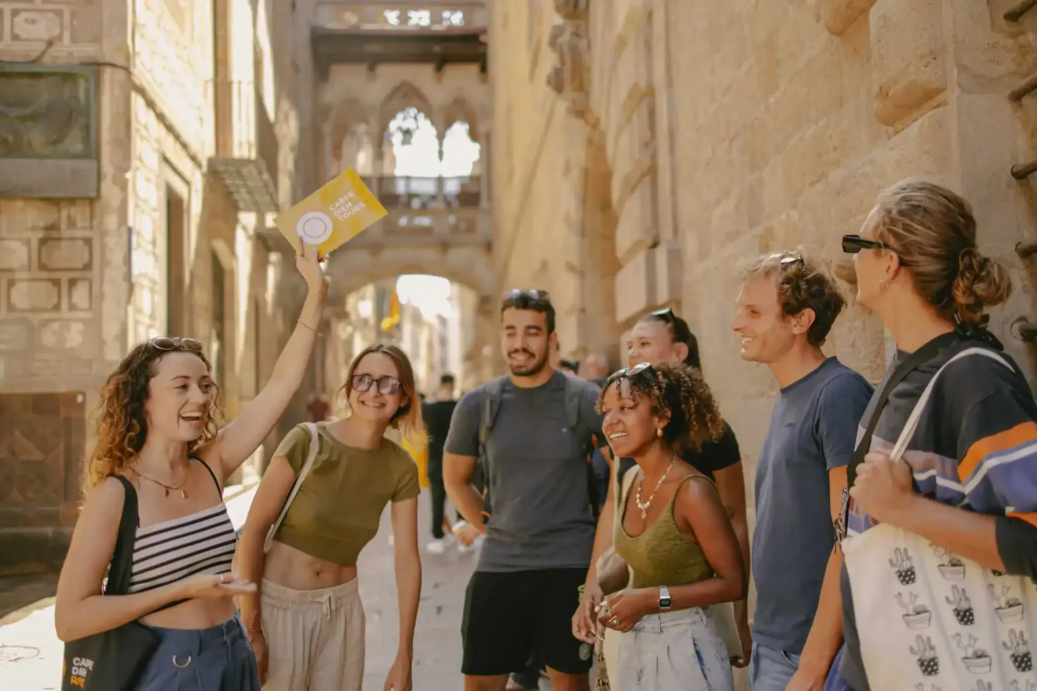 Walking tour group gathered under Gothic archway in Barcelona's historic Gothic Quarter street