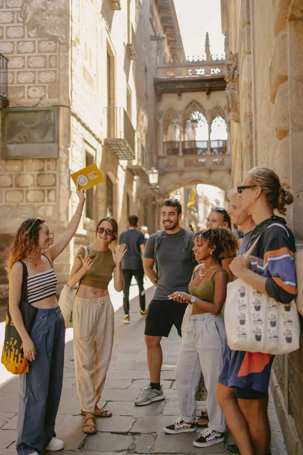 Walking tour group in Barcelona's Gothic Quarter street with medieval architecture and arched doorways