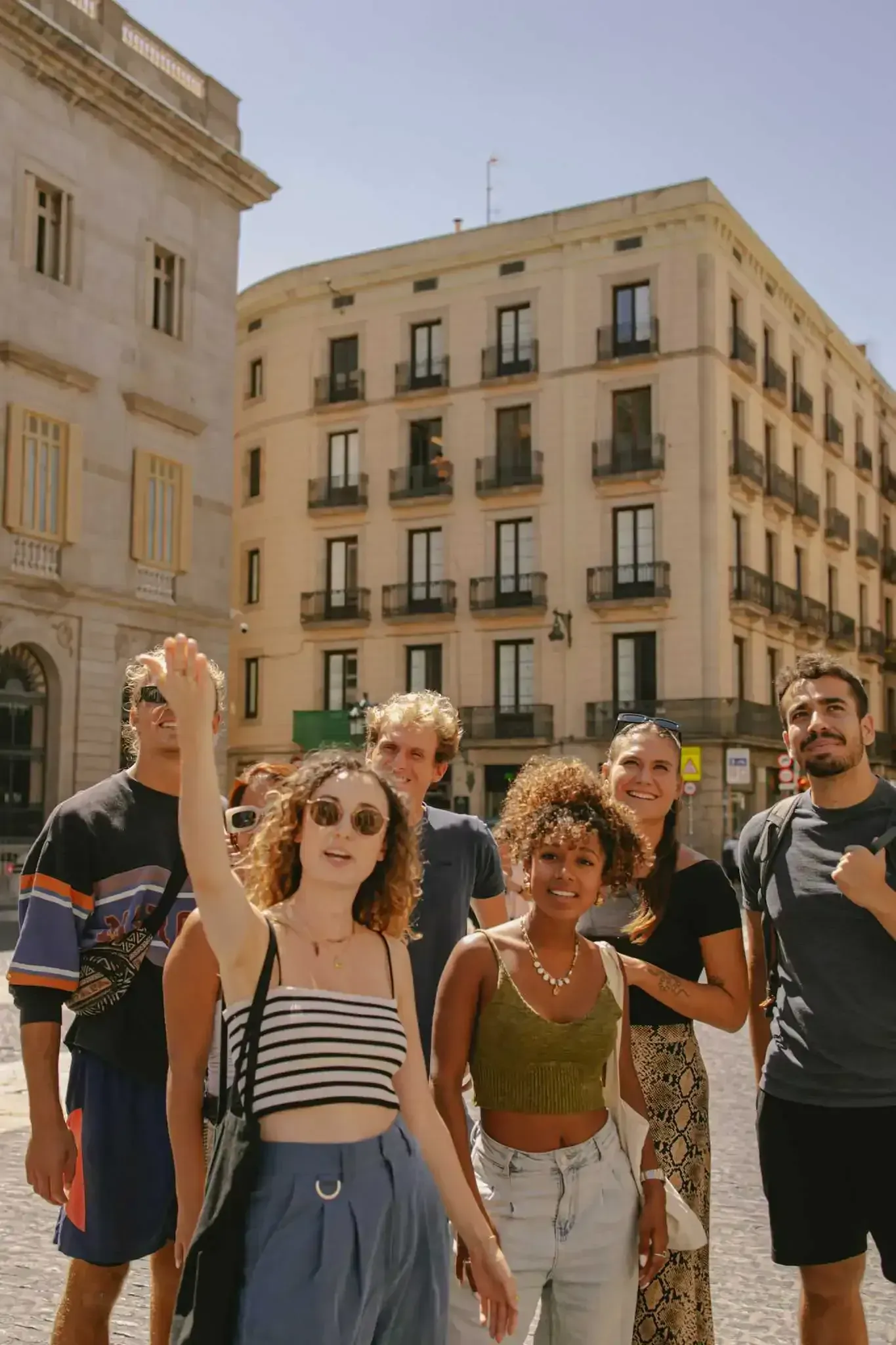 Tour group at Plaça Reial in Barcelona with historic neoclassical buildings and palm trees