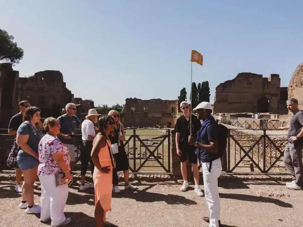 Licensed guide explaining Colosseum arena history to small group of tourists