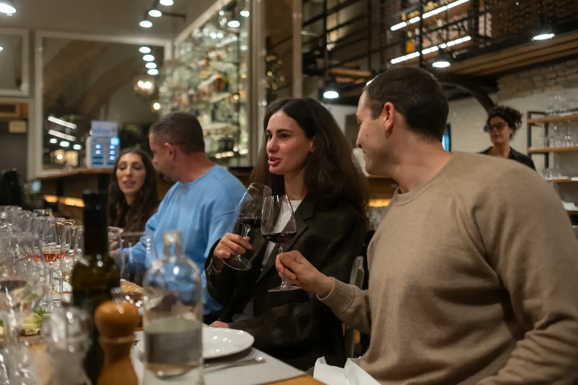 A couple talking and enjoying a glass of red wine during a tasting experience.