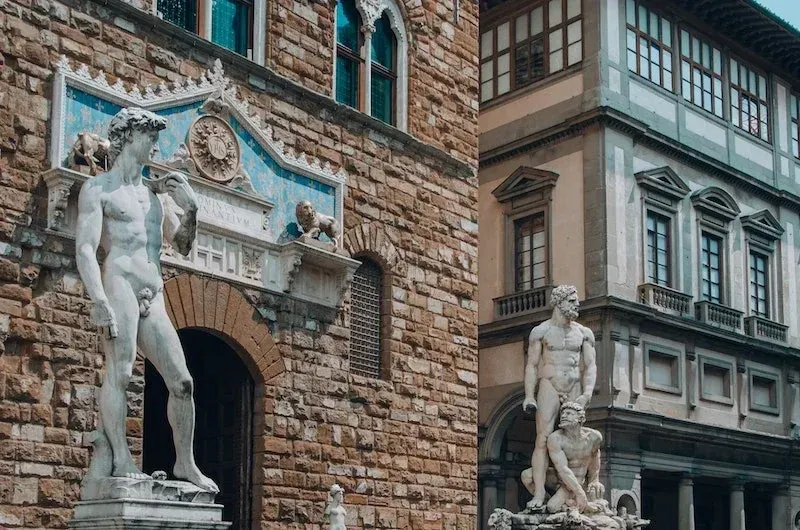 Replica of Michelangelo's David statue outside Palazzo Vecchio with Renaissance architecture and Uffizi Gallery in Florence