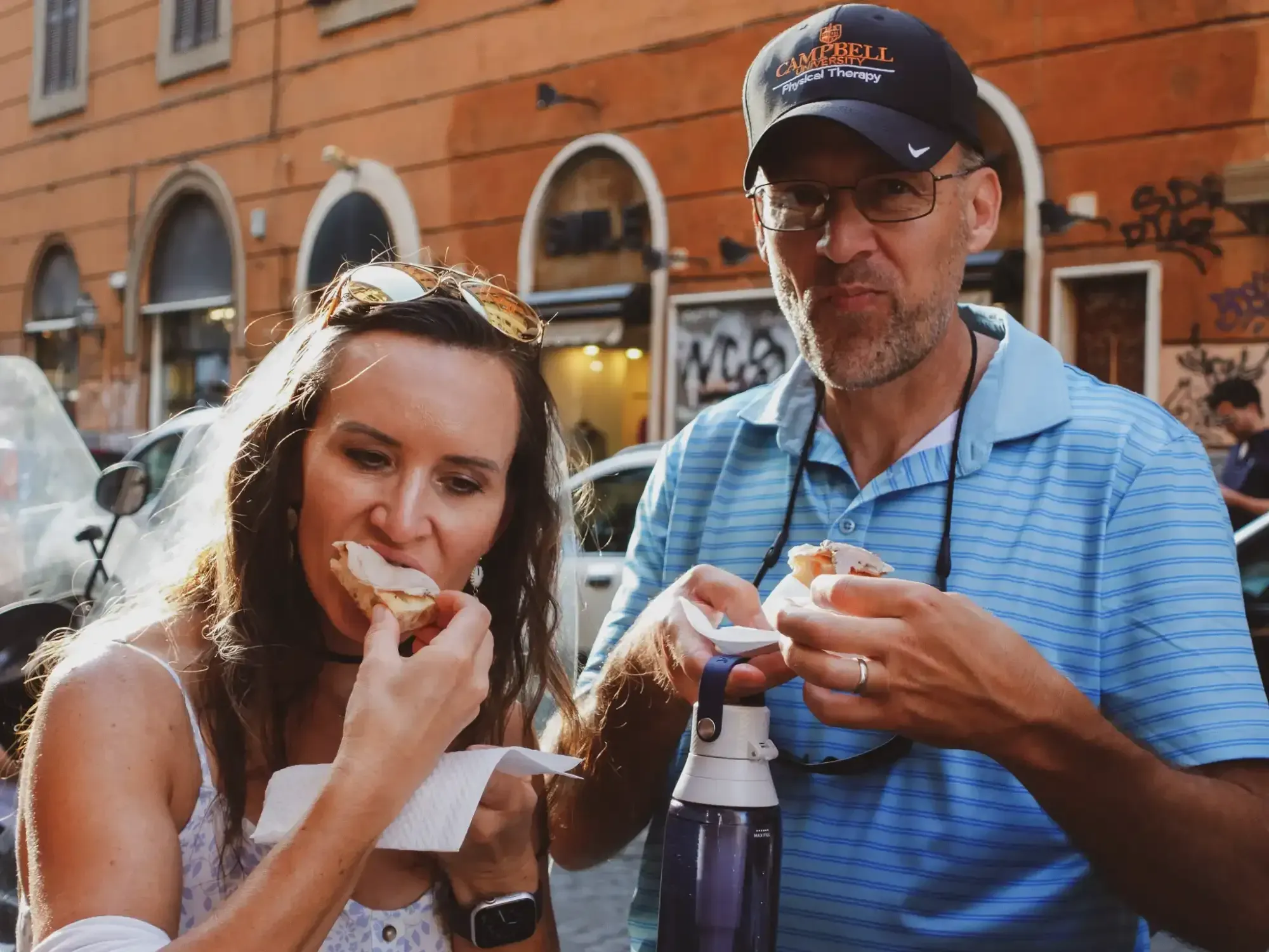 Couple enjoying porchetta with pizza bianca on the best food tour in Rome