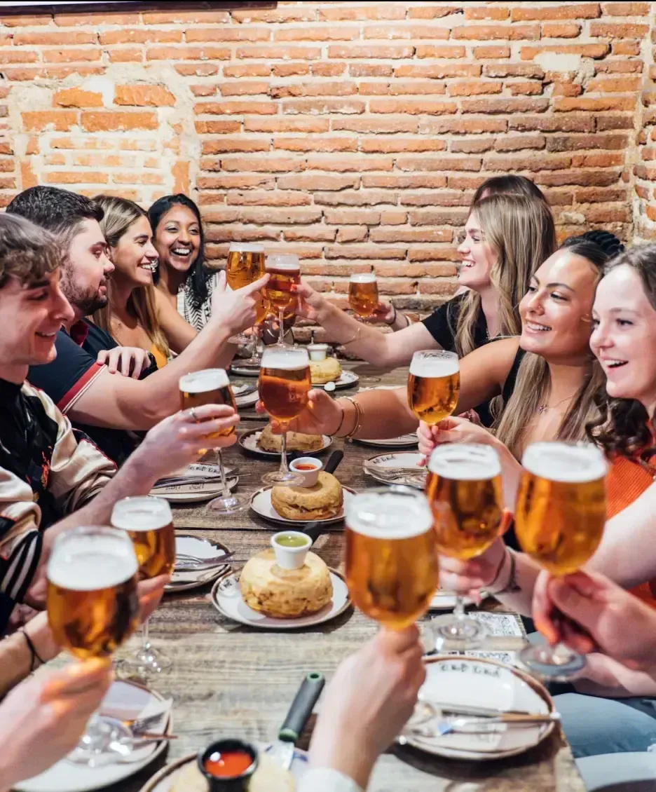 Group of friends enjoying tapas and drinks together at a traditional Madrid restaurant