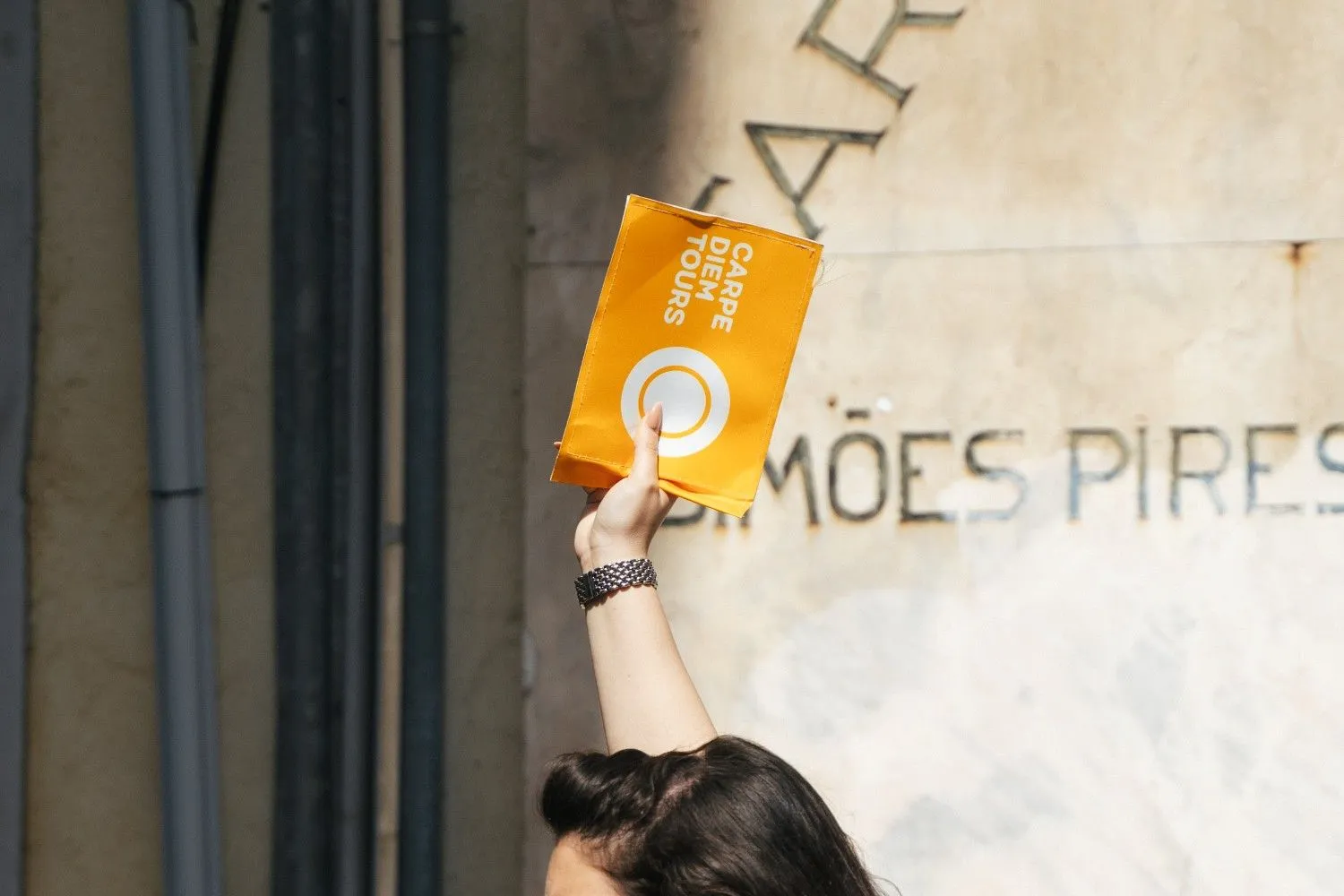 Carpe Diem Tours yellow flag held up at the Lisbon Food Tour meeting point in Baixa