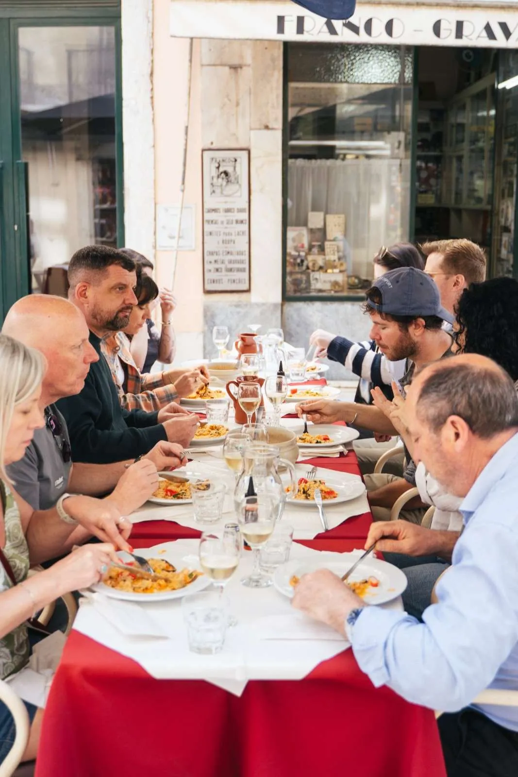 Foodie group sharing seafood rice and Vinho Verde at a traditional Lisbon restaurant