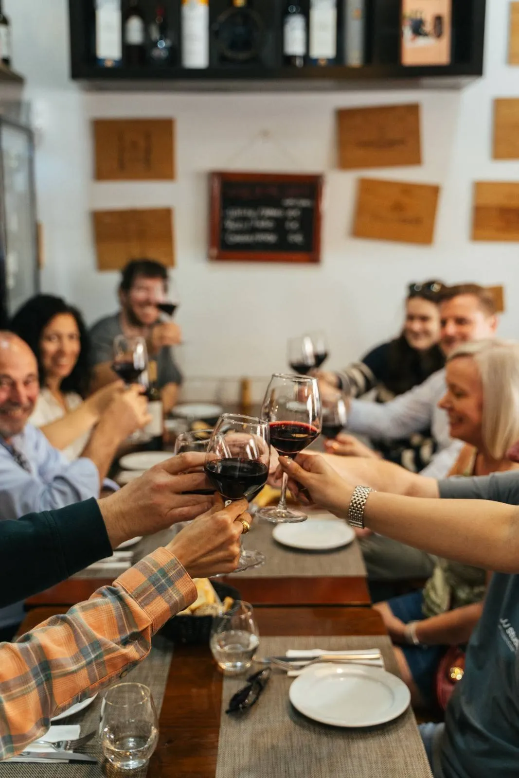 Travellers toasting with Portuguese red wine at a family-run tavern in Lisbon Baixa
