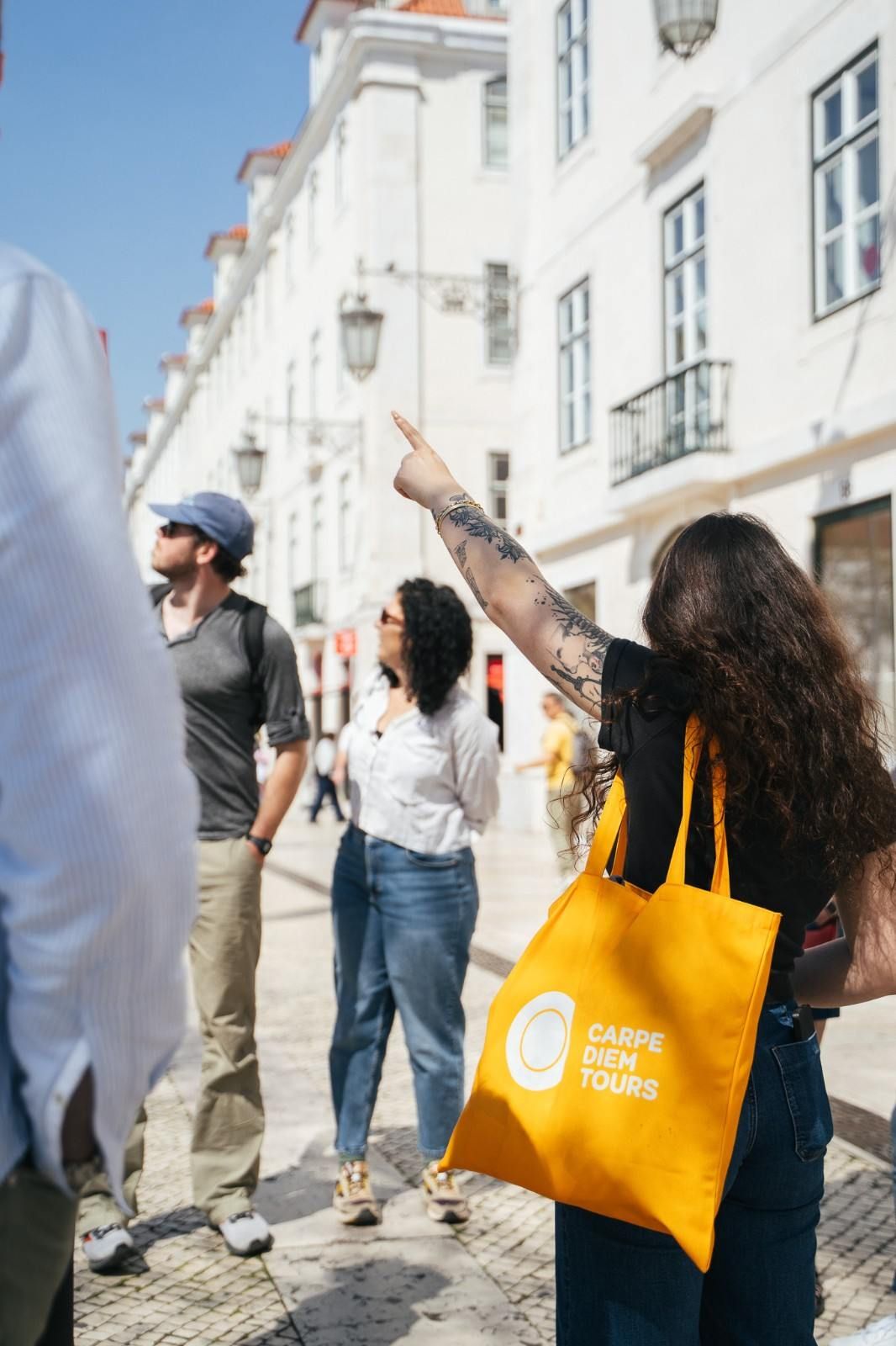 Carpe Diem Tours guide pointing up at Lisbon architecture for guests on the Lisbon Walking Tour