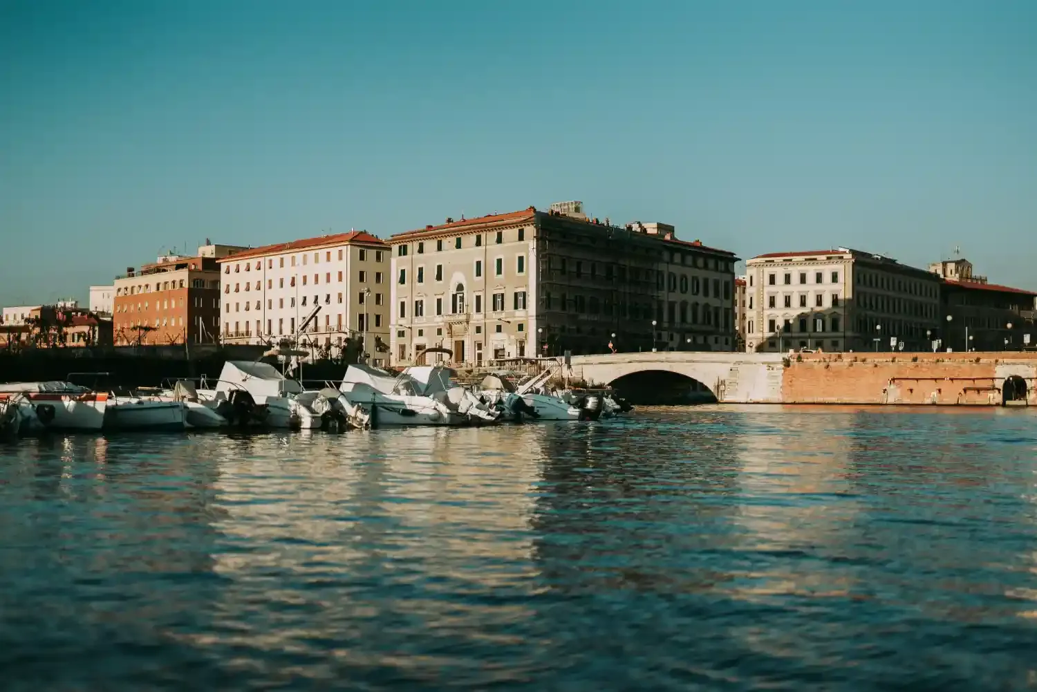 Livorno harbor with traditional fishing boats historic buildings and turquoise Mediterranean water