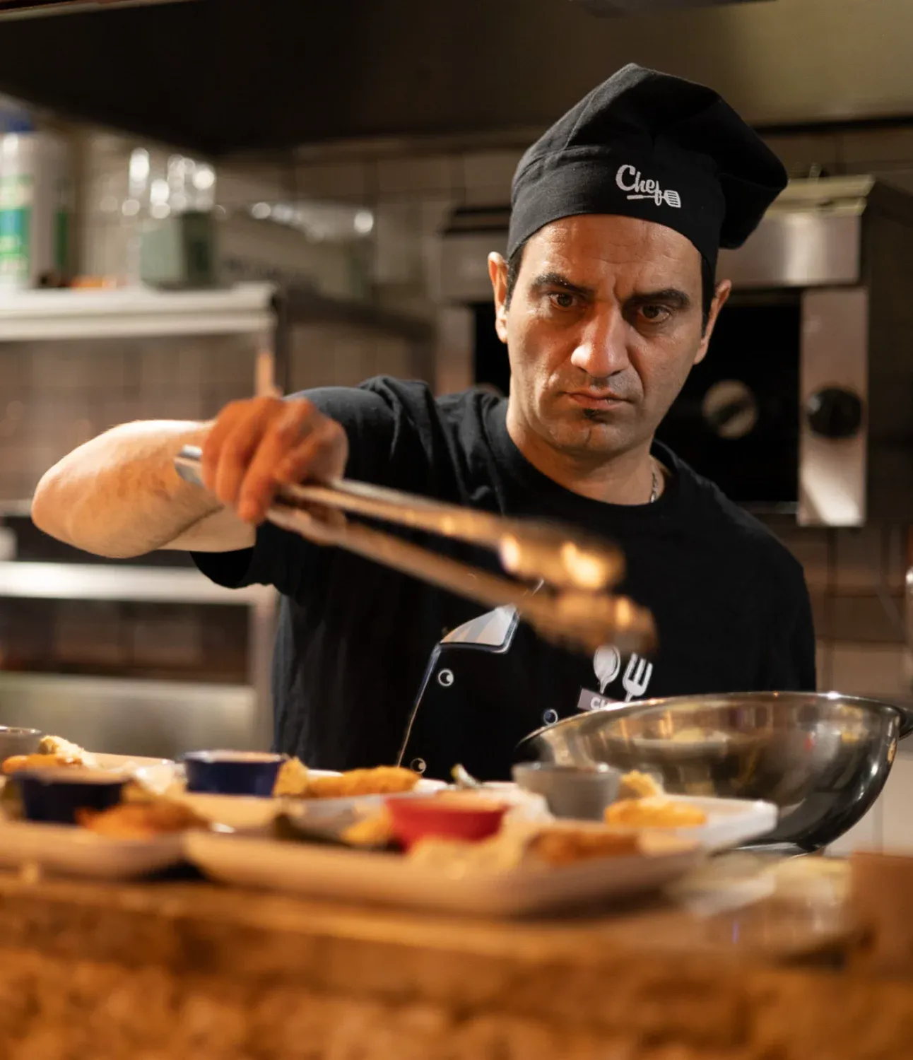 Chef preparing traditional food in kitchen setting during London Soho Food Tour