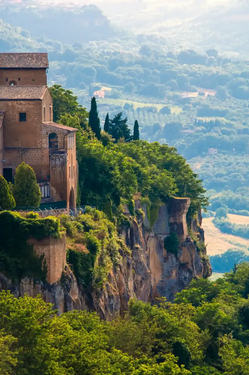 Historic cliffside town of Orvieto with medieval buildings cypress trees and panoramic view of Umbrian countryside