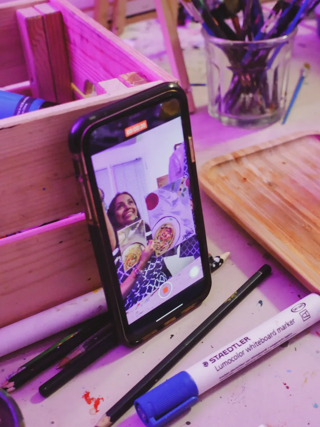 Smartphone screen showing participants taking a photo during the painting with wine class experience