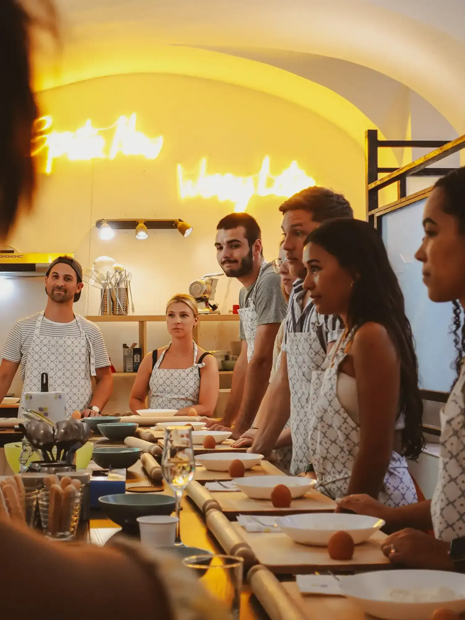 Group of cooking class participants seated at table enjoying their prepared dishes during Pasta & Tiramisu experience