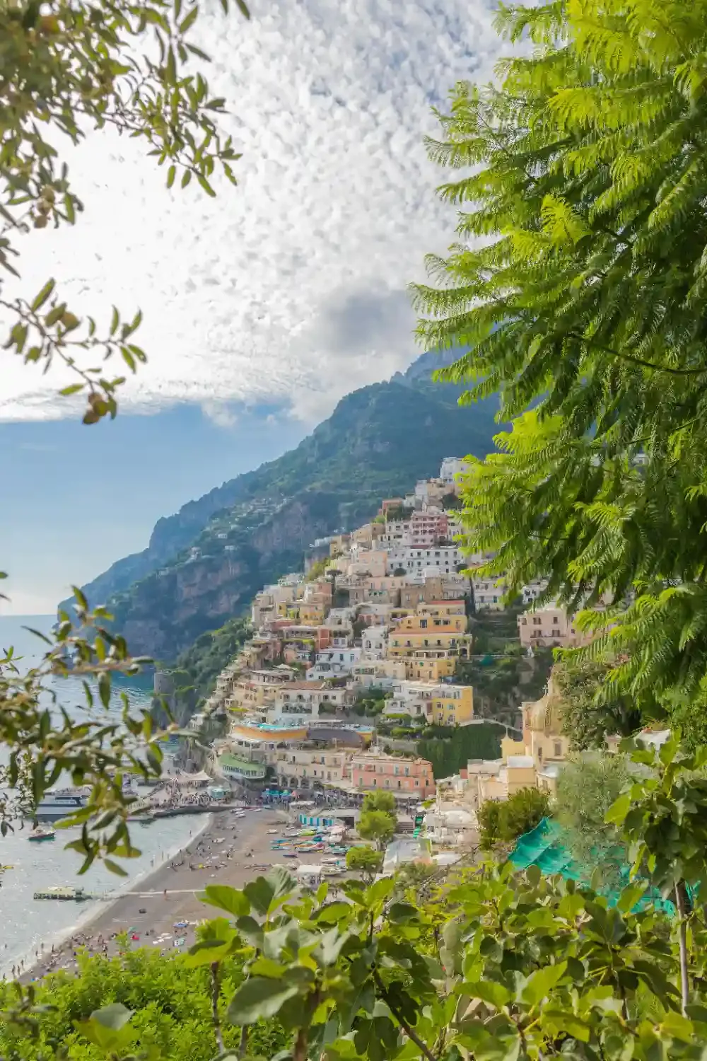 Positano village with colorful pastel buildings cascading down dramatic cliffs overlooking turquoise Mediterranean Sea