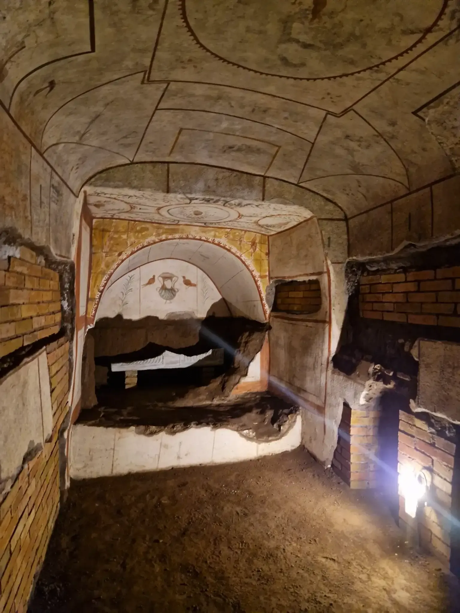 Tourists exploring narrow corridors in Rome's underground catacombs