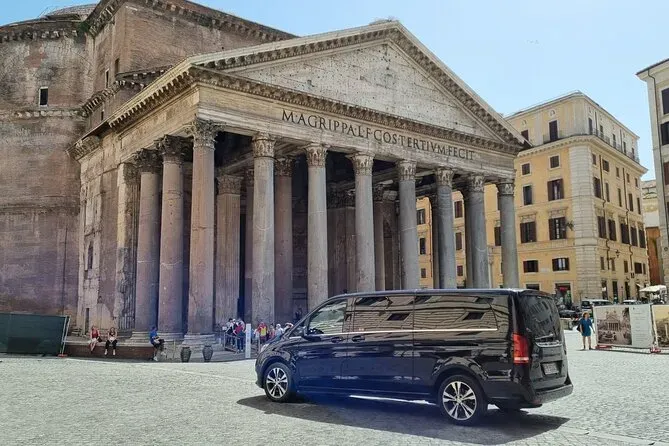 Luxury blue minivan parked in front of the ancient Pantheon with its distinctive classical columns and historic Roman architecture