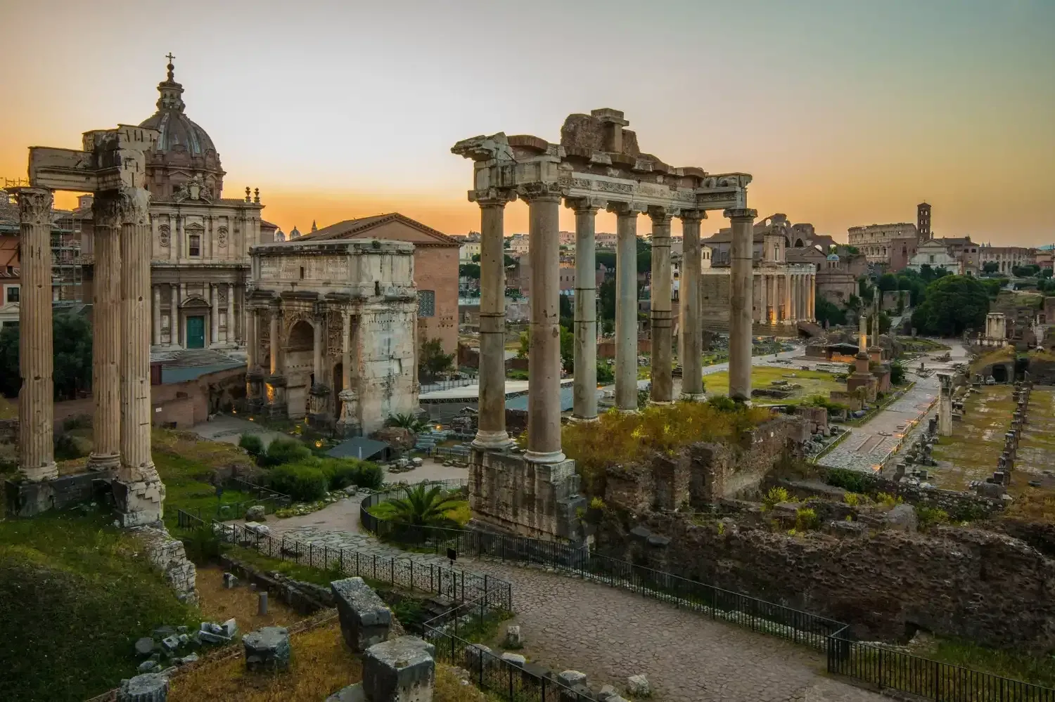 Roman Forum archaeological site at sunrise with ancient temple columns, historical ruins, and golden light illuminating the historic site