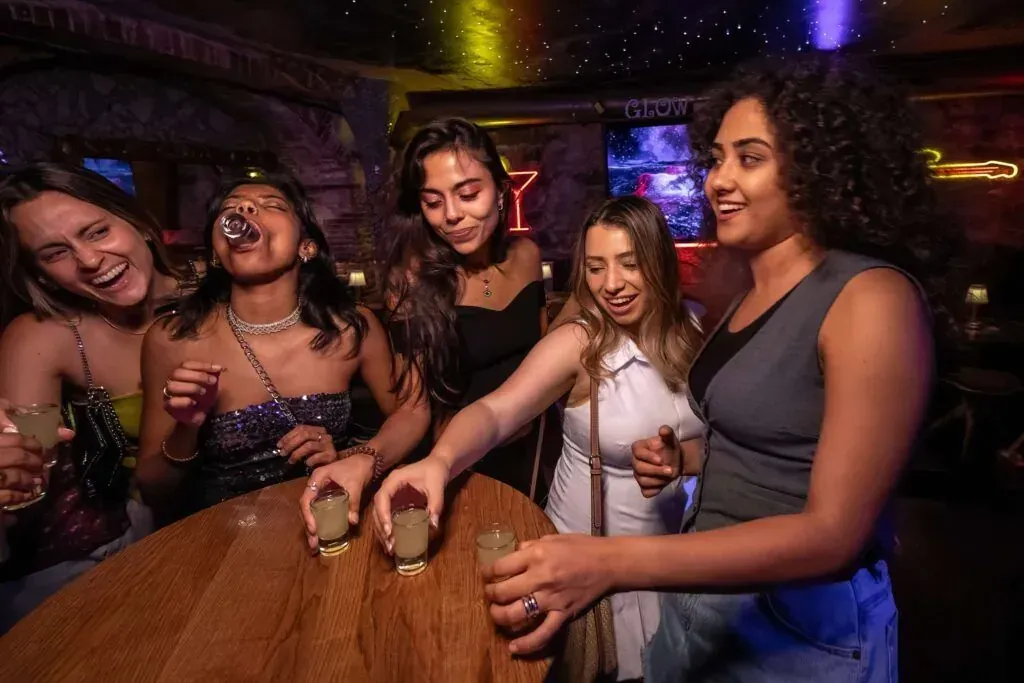 Happy group of friends enjoying Barcelona Tipsy Tour nightlife experience showcasing social drinking and bar hopping culture featured in Carpe Diem Tours Barcelona nightlife exploration and entertainment adventure